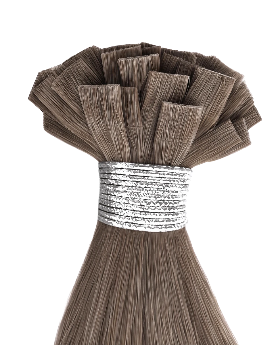A bundle of light brown hair extension or wig fibers with a silver elastic band, isolated on a solid white background.